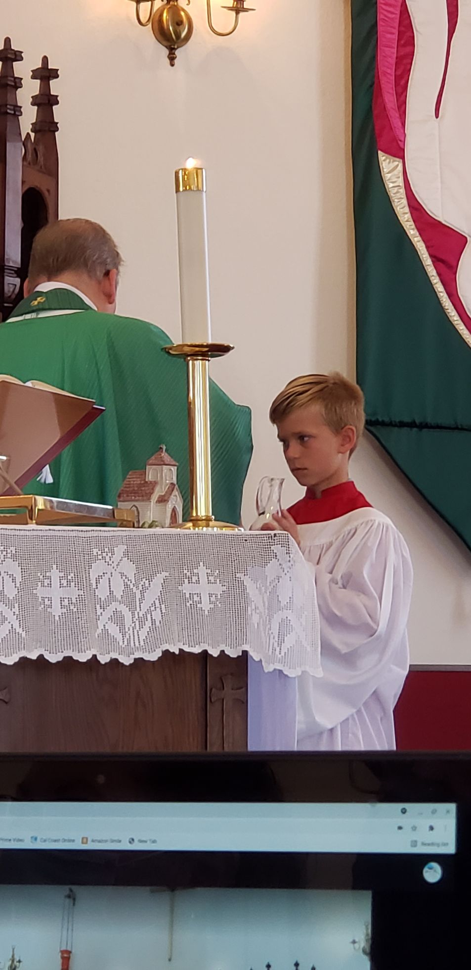 A young boy is standing in front of an altar in a church.