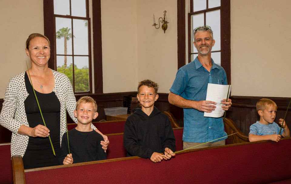 A family is sitting on a bench in a church.