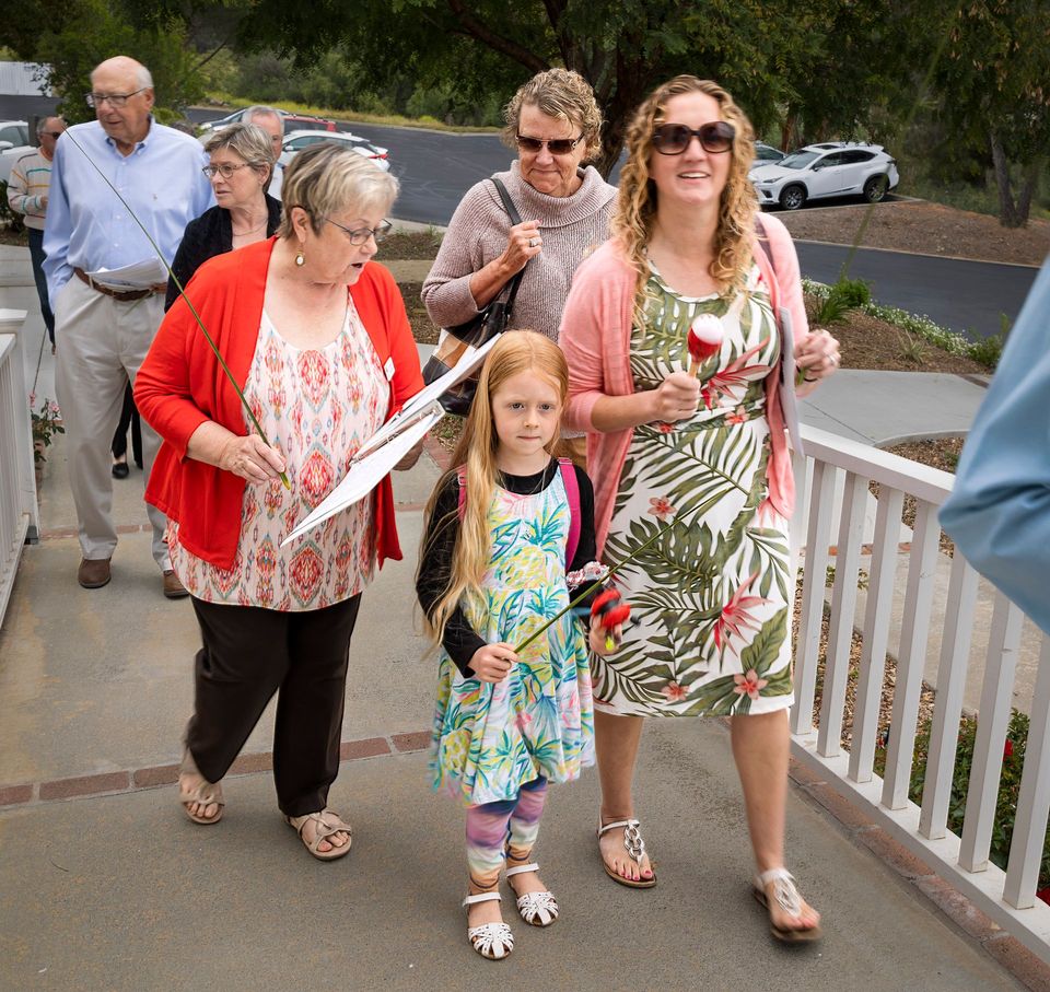 A group of women and a little girl are walking down a sidewalk
