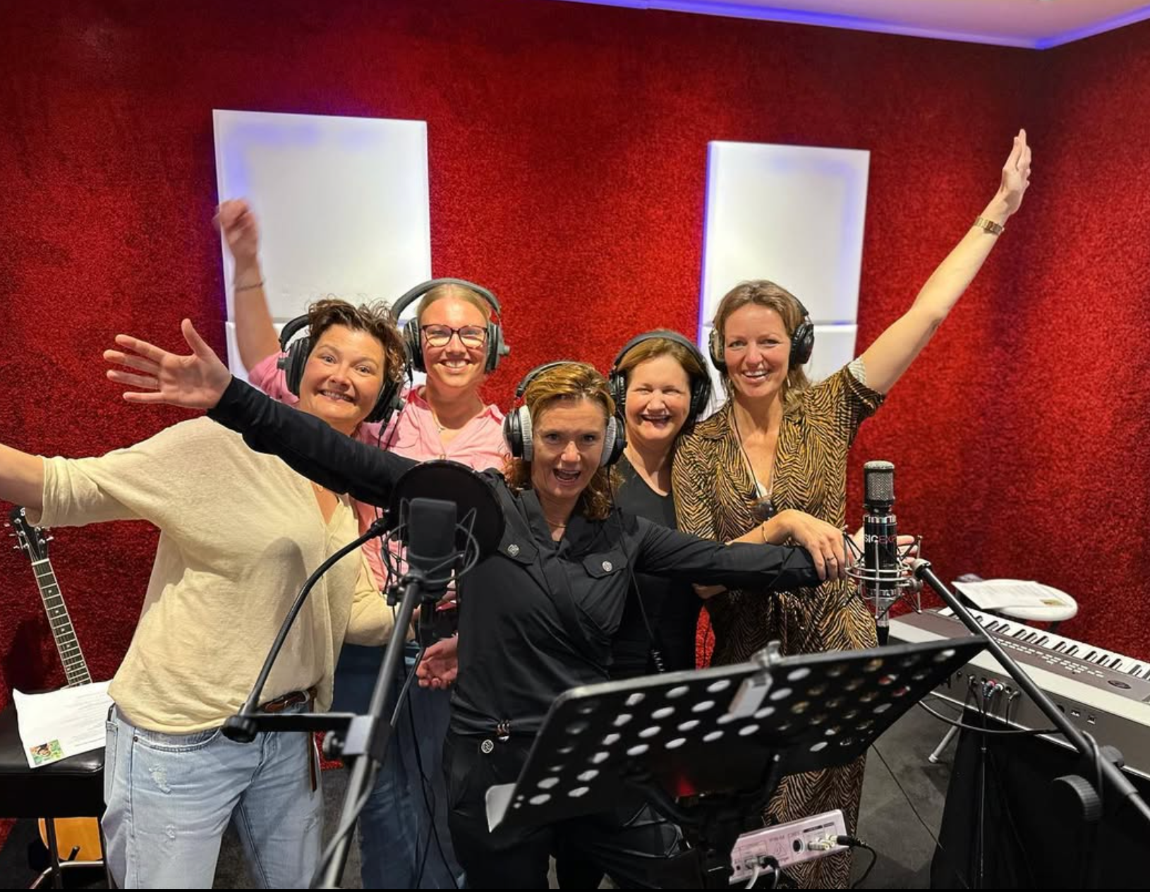 Een groep vrouwen met koptelefoons in een opnamestudio