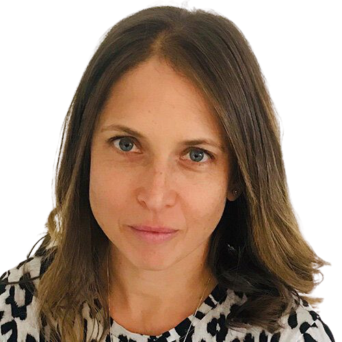 A woman with long hair is wearing a leopard print shirt and looking at the camera.