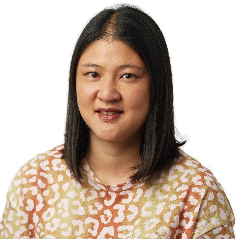 A woman wearing a leopard print shirt is smiling for the camera.