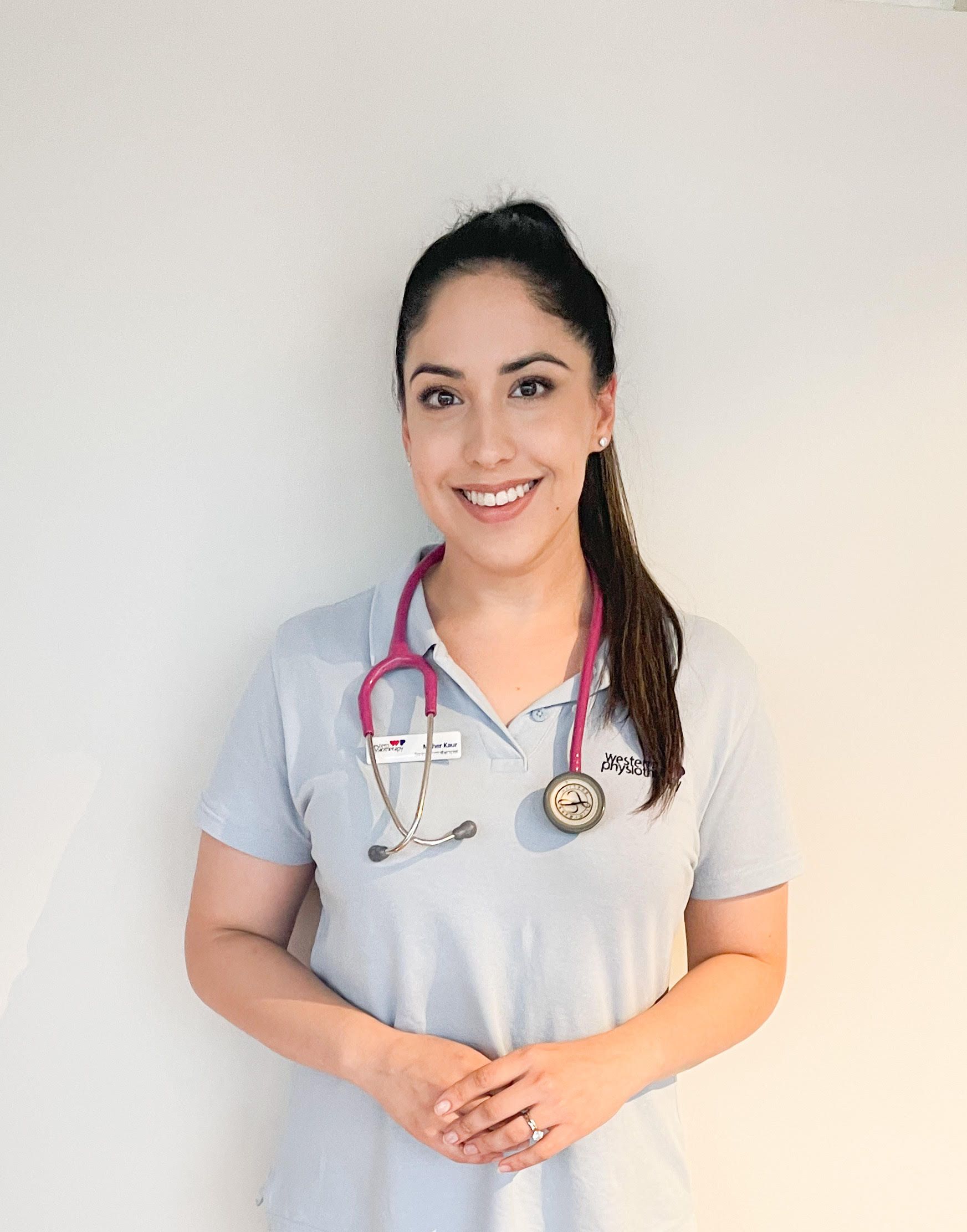 A woman is wearing a stethoscope around her neck and smiling.