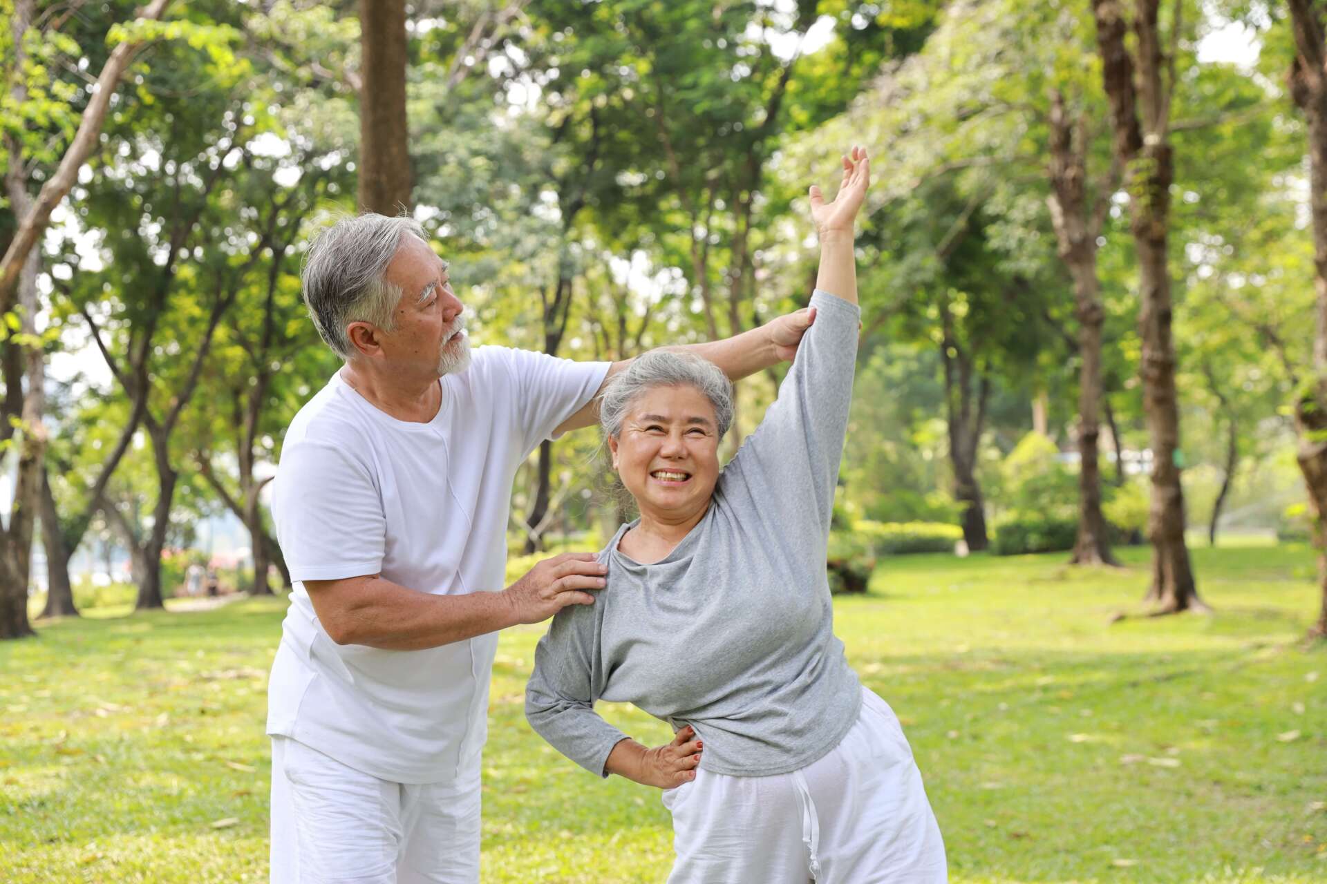 an older couple practicing tai chi outside