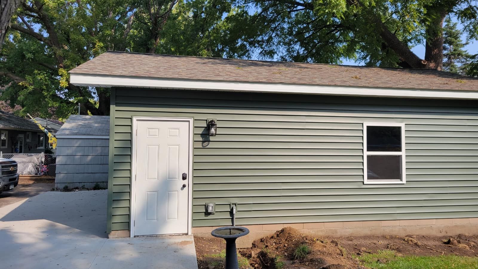 Small modern bathroom with black herringbone floor, white walls, and black vanity.