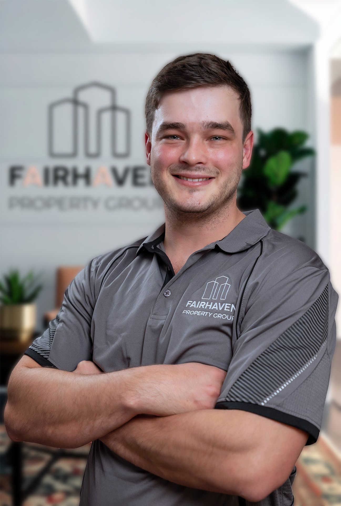Man with arms crossed, smiling, wearing a gray polo shirt. Fairhaven Property Group logo visible in the background.
