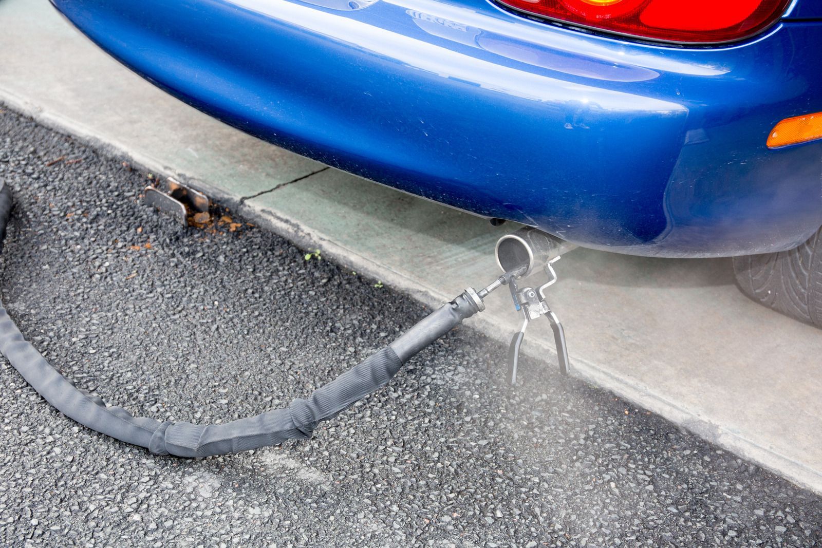 Blue car tailpipe with emissions testing equipment.