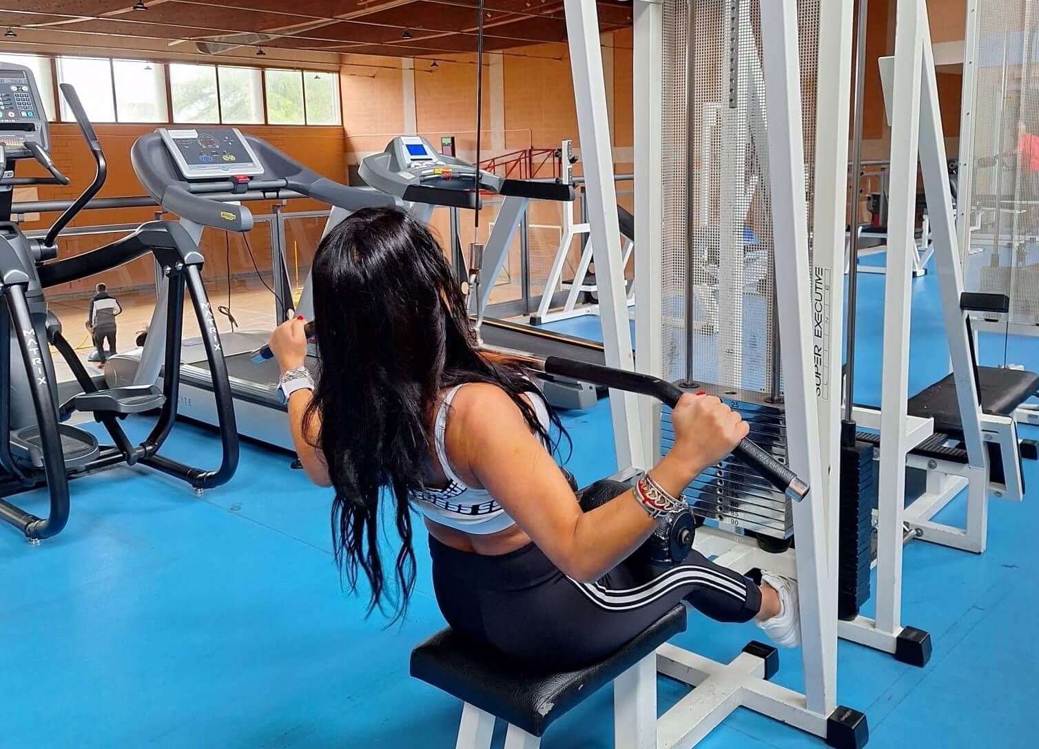 Una donna sta usando un macchinario in palestra.