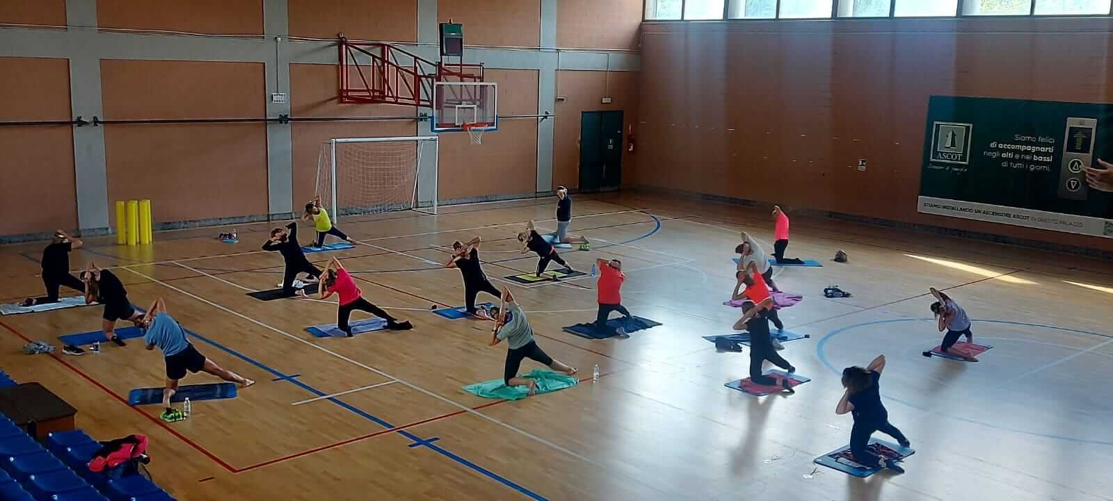 Un gruppo di persone sta facendo yoga in una palestra.