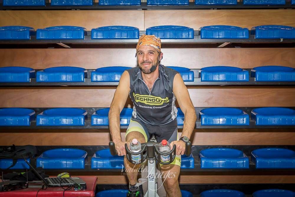 Un uomo sta pedalando su una cyclette in una palestra.
