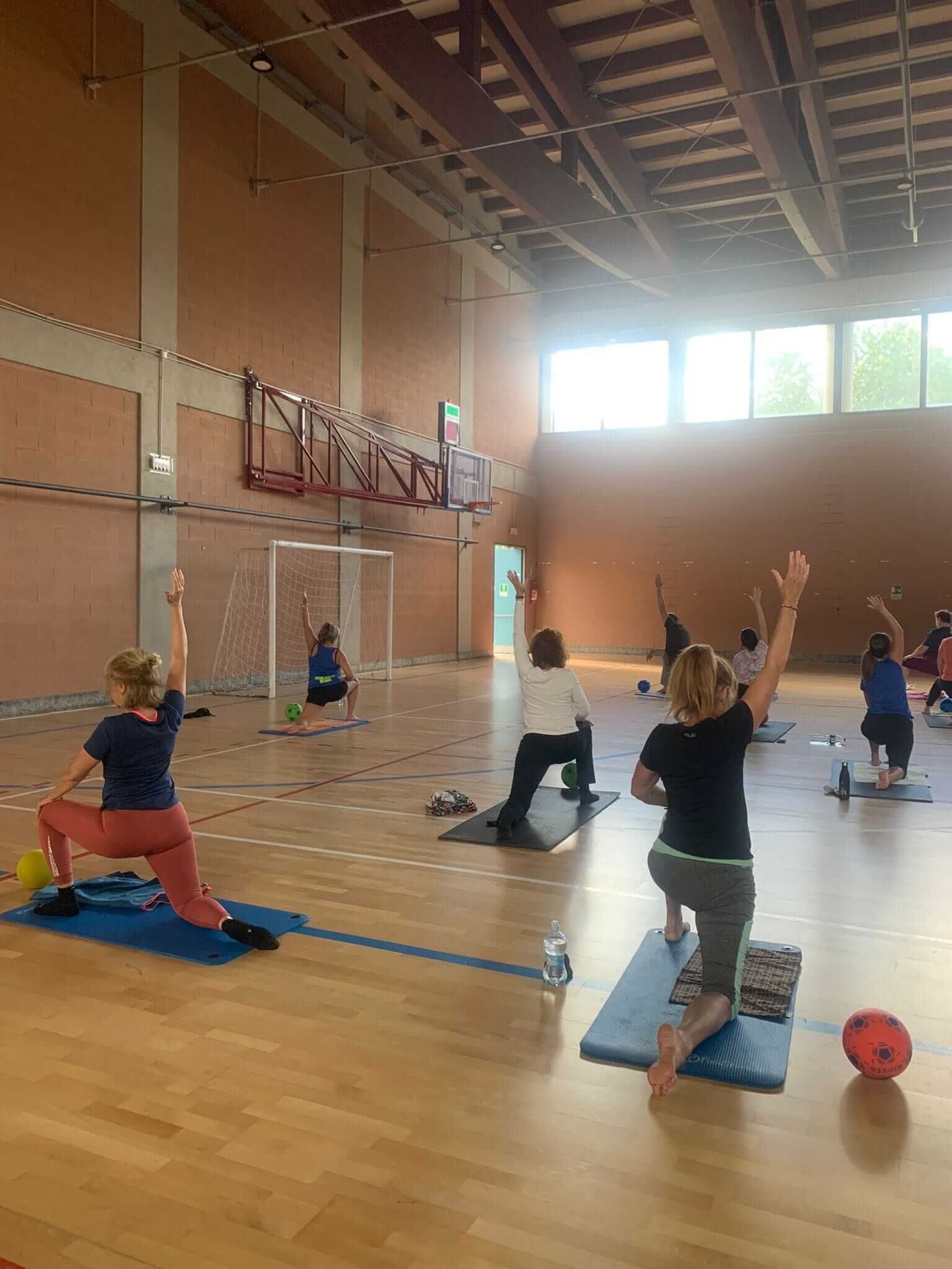 Un gruppo di persone sta facendo yoga in una palestra.