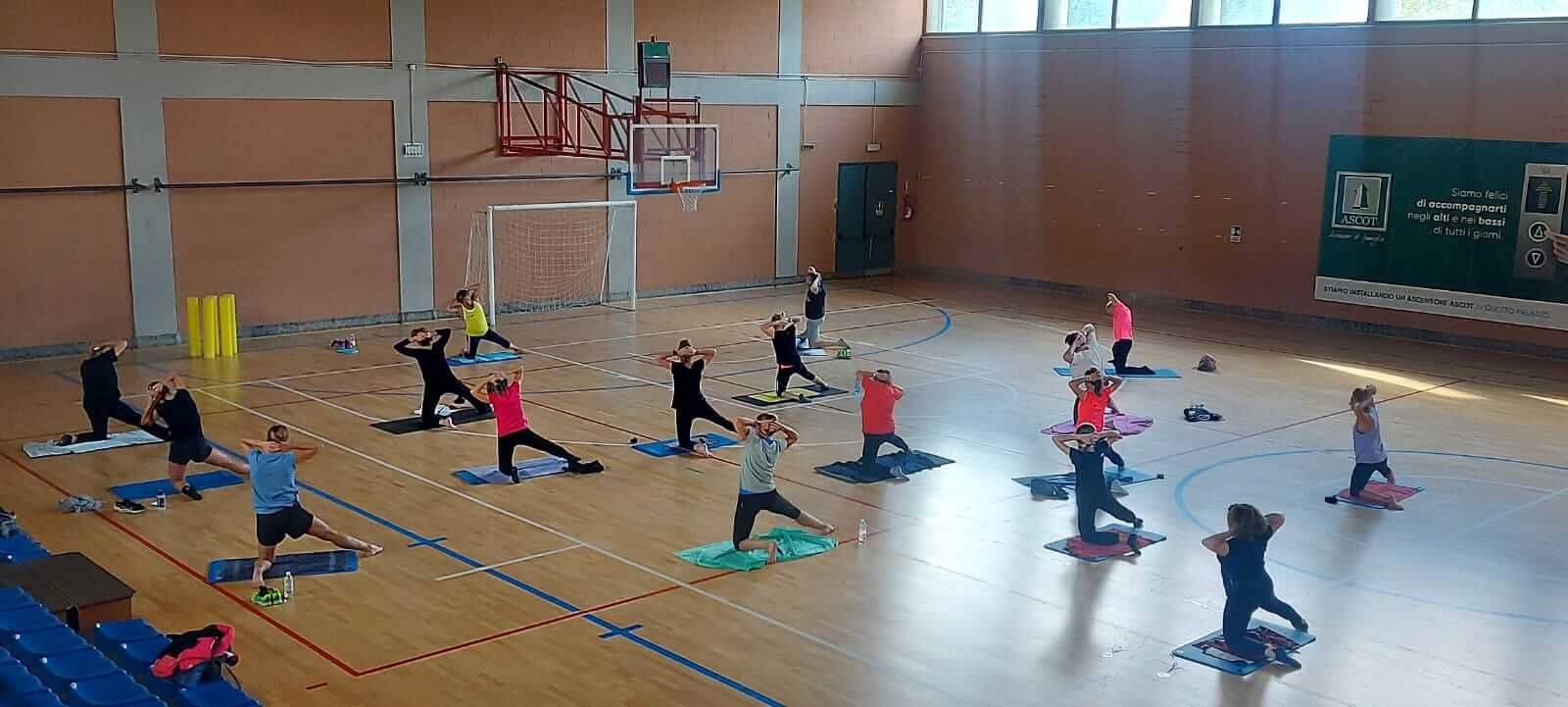 Un gruppo di persone sta facendo yoga in una palestra.