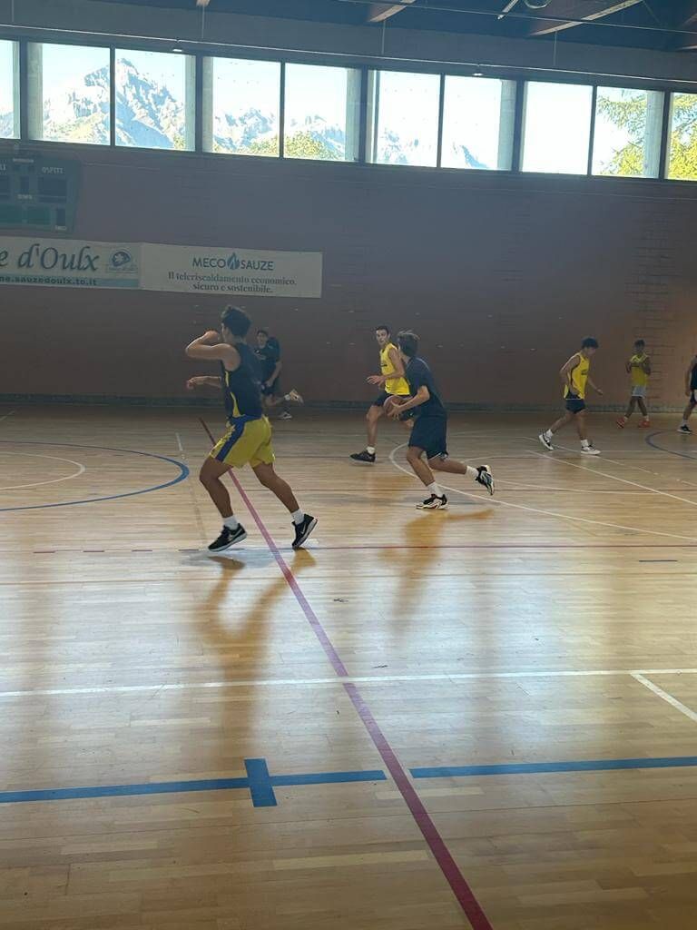 Un gruppo di persone sta giocando a basket in una palestra.