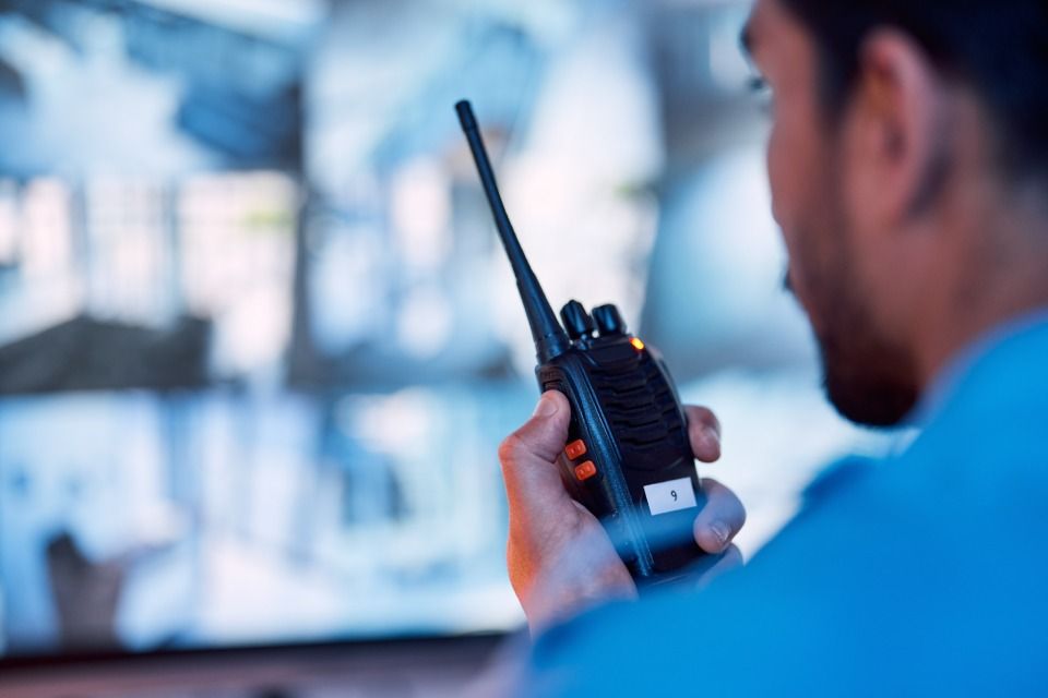 a man is holding a walkie-talkie in front of a monitor.