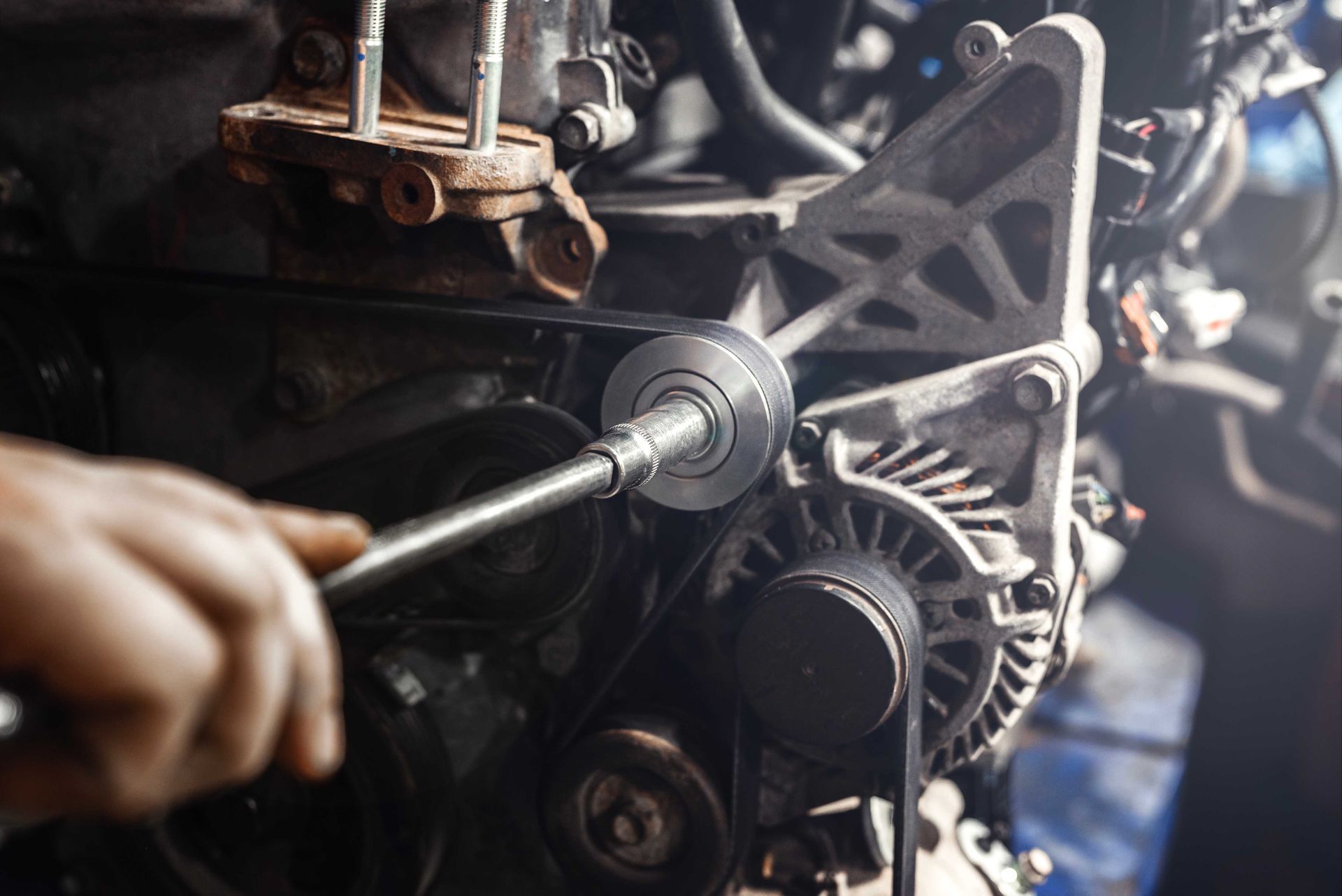 Personne utilisant une clé à molette pour travailler sur un moteur de voiture.