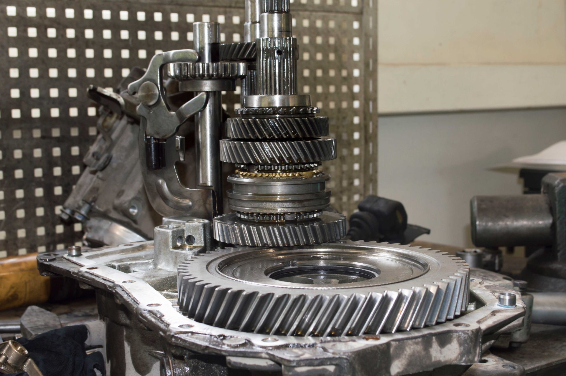Engrenages de transmission démontés pour réparation, posés sur une surface d'atelier.