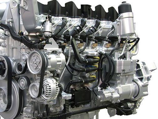 Moteur diesel argenté avec divers composants, courroies et câblage.