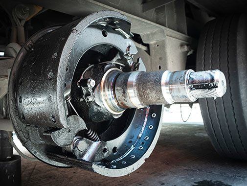 Ensemble de freins à tambour pour camion, composants métalliques noirs et argentés, vu en gros plan.