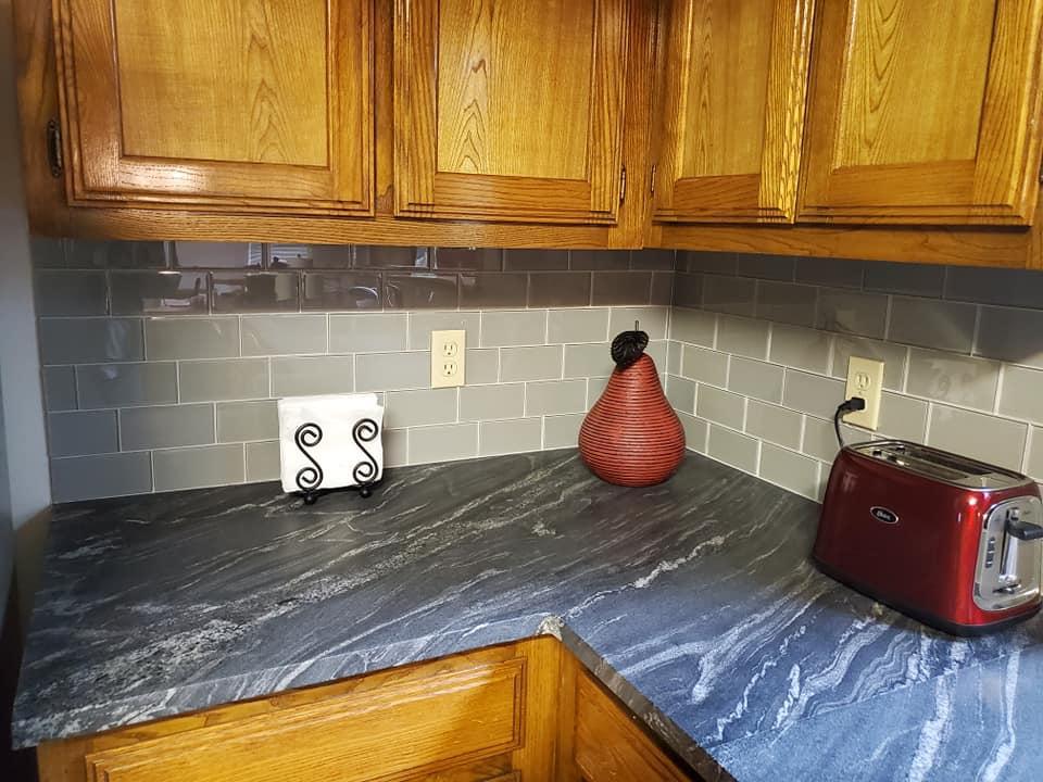 A kitchen counter with a toaster and a vase on it.