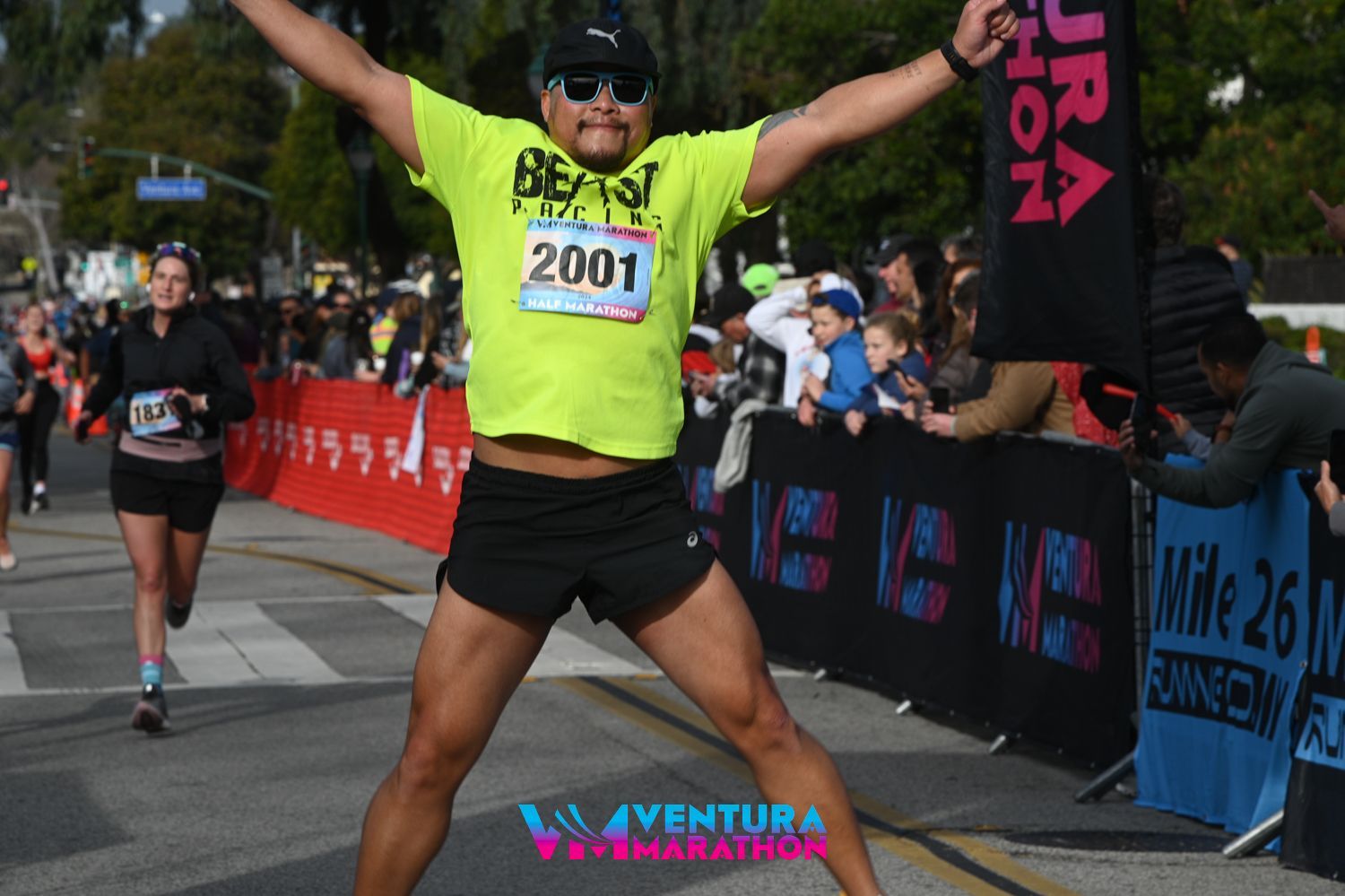 Runner from beast Pacing jumping in the air across the Ventura Marathon Finish Line