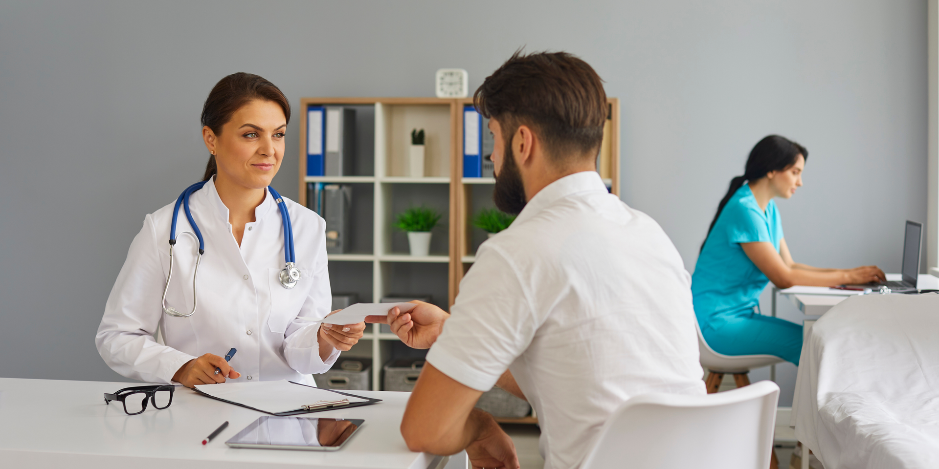 A footcare specialist consulting with a male patient inside a private office at a footcare centre.