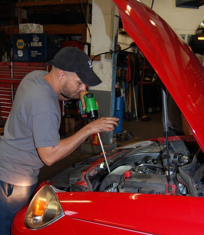Man Fixing the Car's Engine — Chicopee, MA — Lloyd's Transmission Inc.