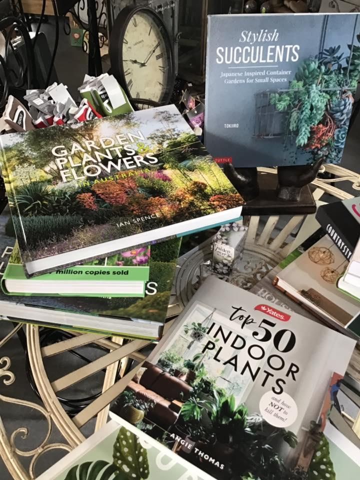 A Bunch Of Books Are Stacked On Top Of Each Other On A Table — Magnolia Nursery In Dubbo, NSW