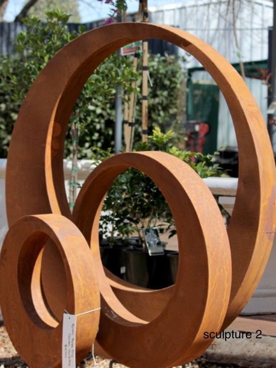 Three Black Pears Are Sitting On A Brick Sidewalk — Magnolia Nursery In Dubbo, NSW