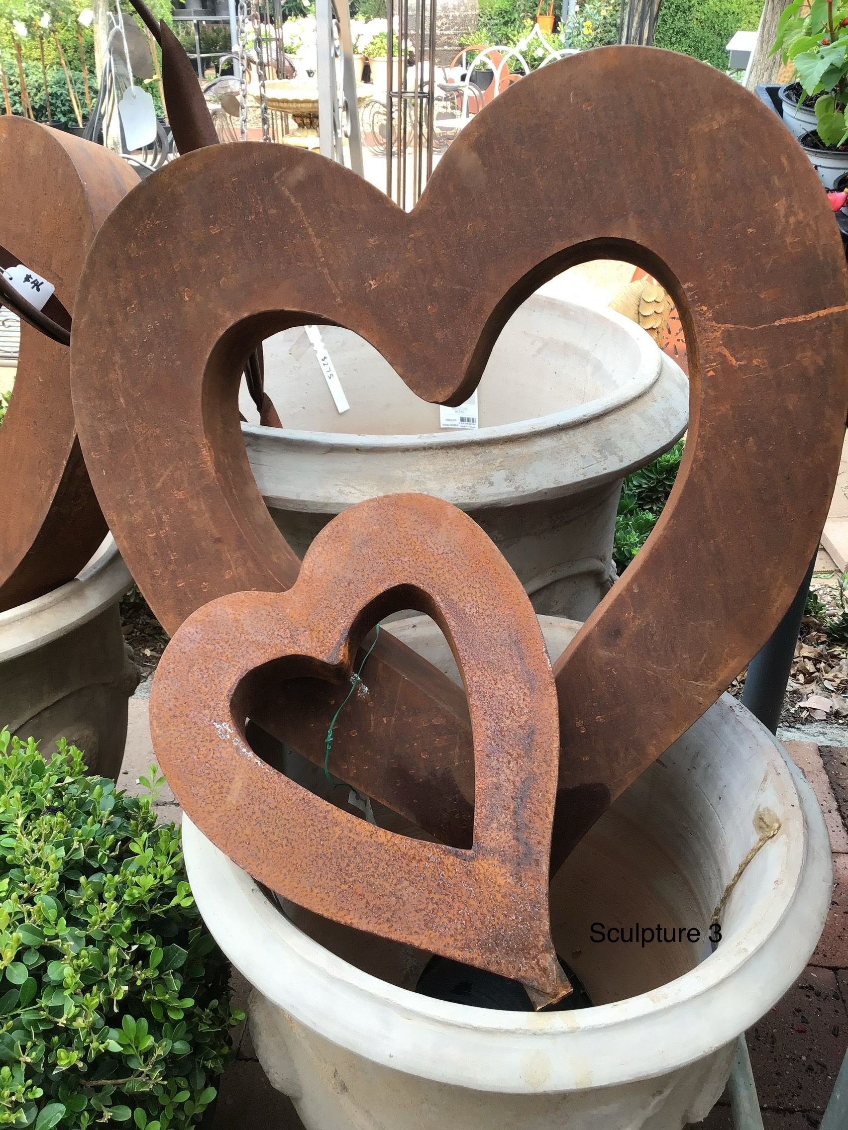 Three Wooden Ducks Are Standing Next To Each Other On A Sidewalk — Magnolia Nursery In Dubbo, NSW