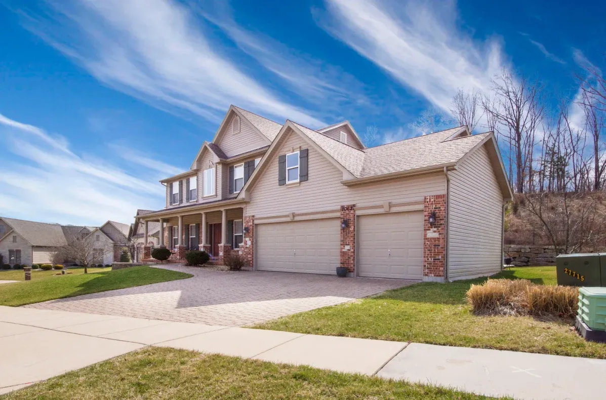 A large house with two garage doors in a residential neighborhood.