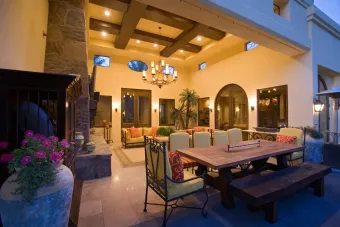 A large patio with a table and chairs and a fireplace