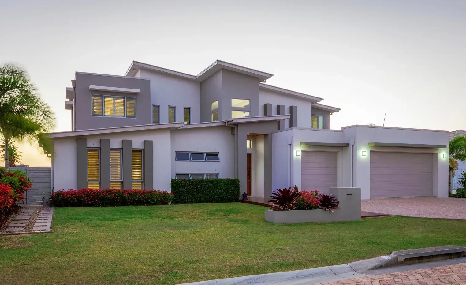 A large white house with a lush green lawn in front of it