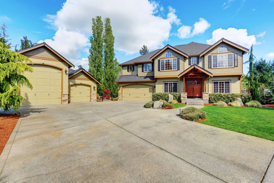 A large house with a large driveway in front of it.