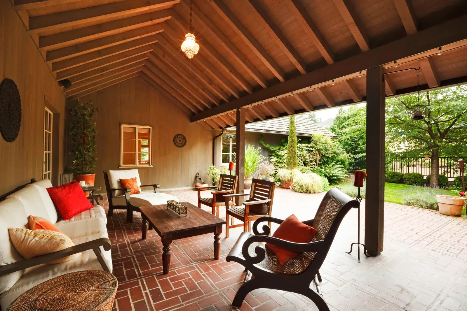 A living room with a couch and chairs under a wooden roof