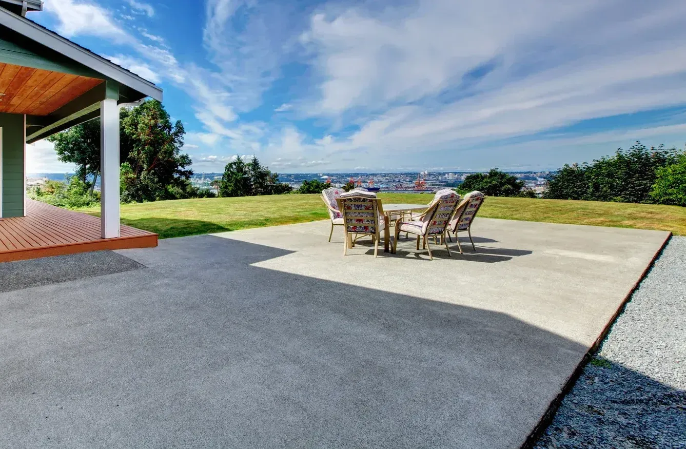 A patio with a table and chairs in front of a house.