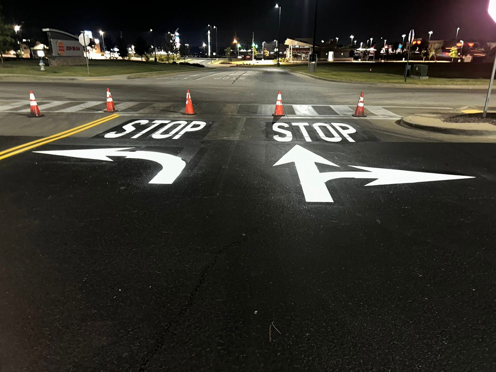 Overhead view of a freshly paved intersection with painted arrows and 