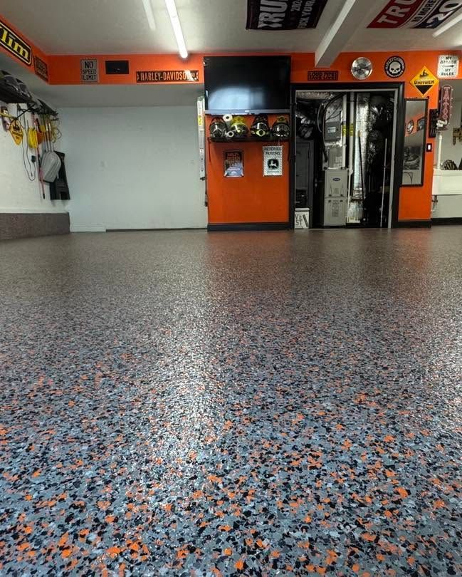 Empty indoor space with speckled floor, orange walls, and glass doors at the back