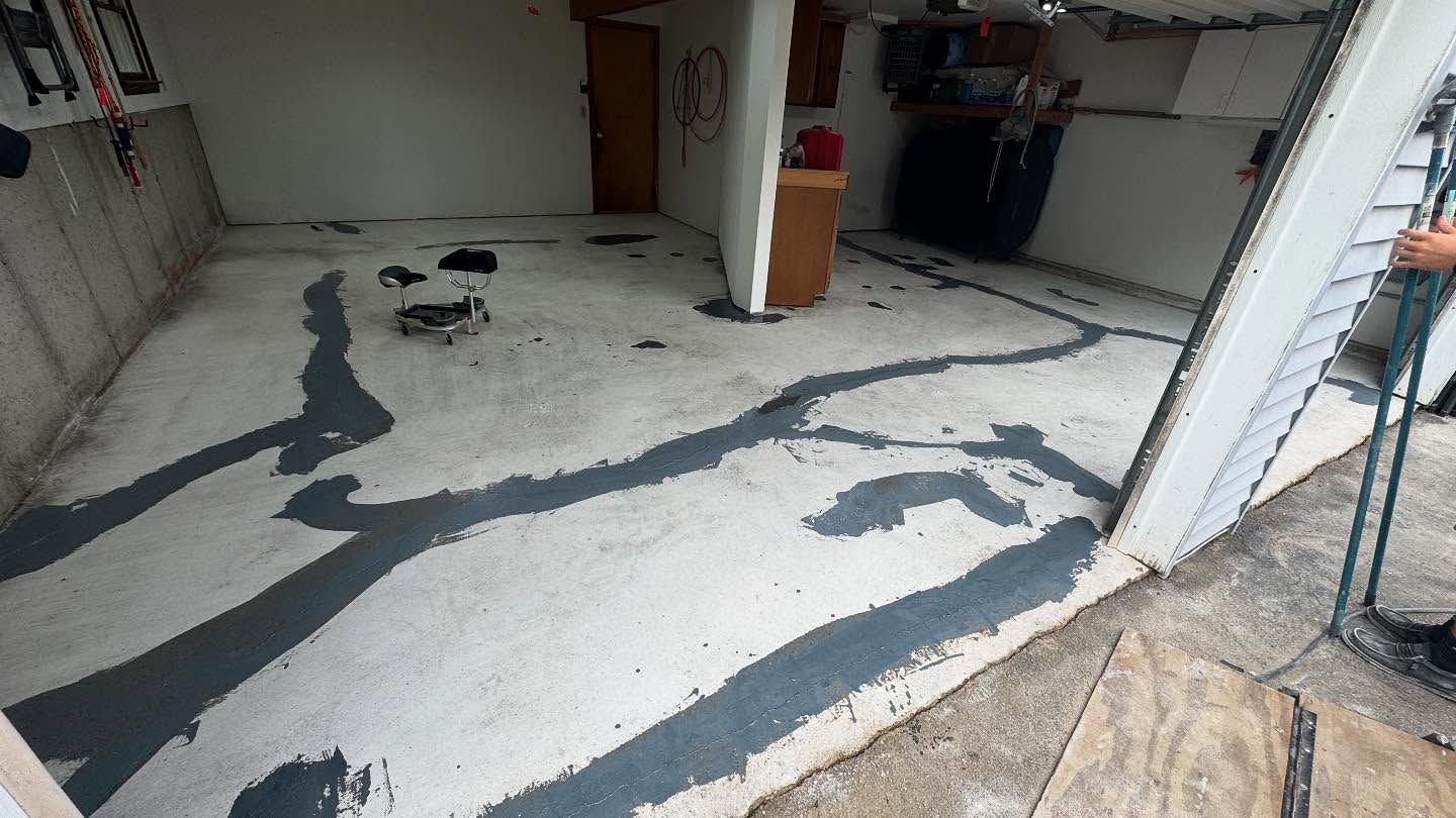 White epoxy floor under construction with black sealant lines in a garage interior