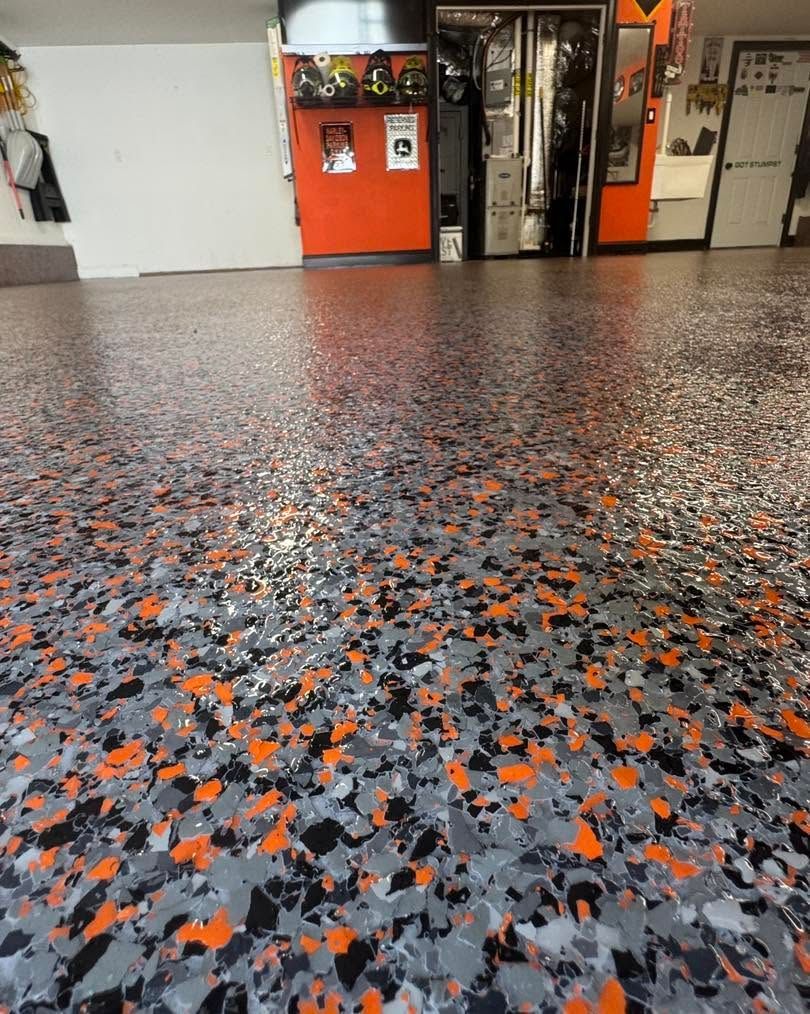 Speckled black, gray, and orange floor in an indoor room with cabinets and doors in the background