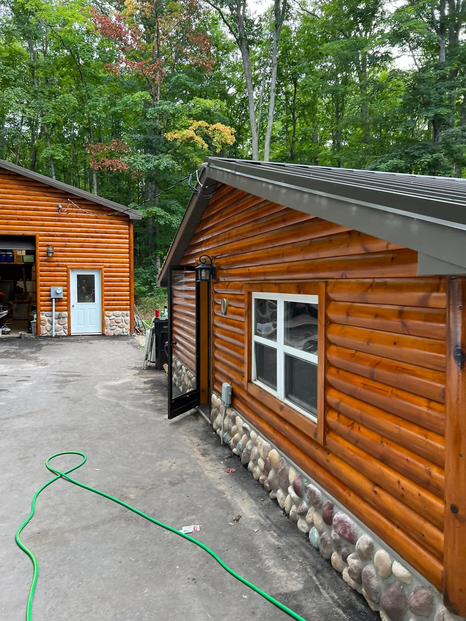Mobile home with a deck and surrounding trees on a grassy area.