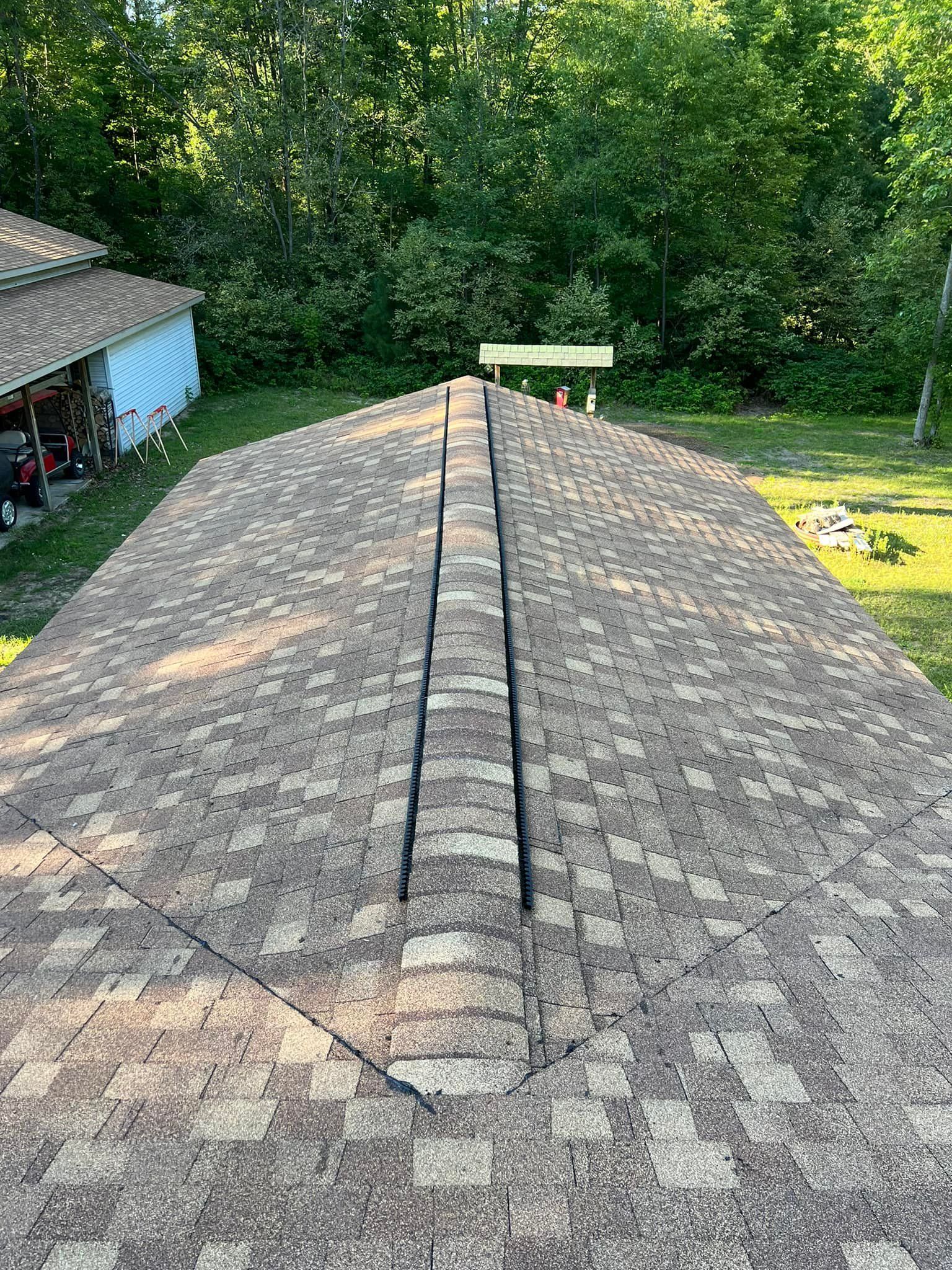 Two men building a retaining wall with construction equipment and supplies.