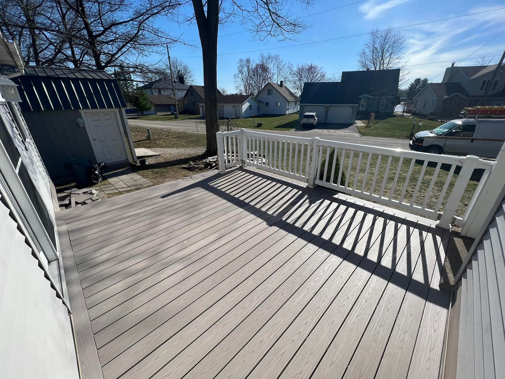Stone retaining wall under construction next to a pile of gravel with buildings in the background.