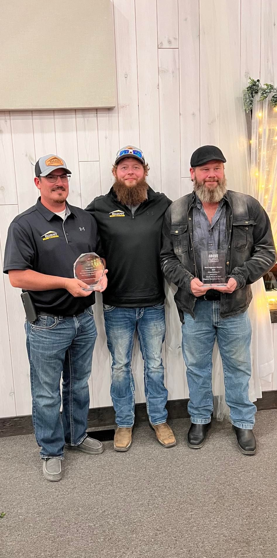 Mobile home with a deck and surrounding trees on a grassy area.