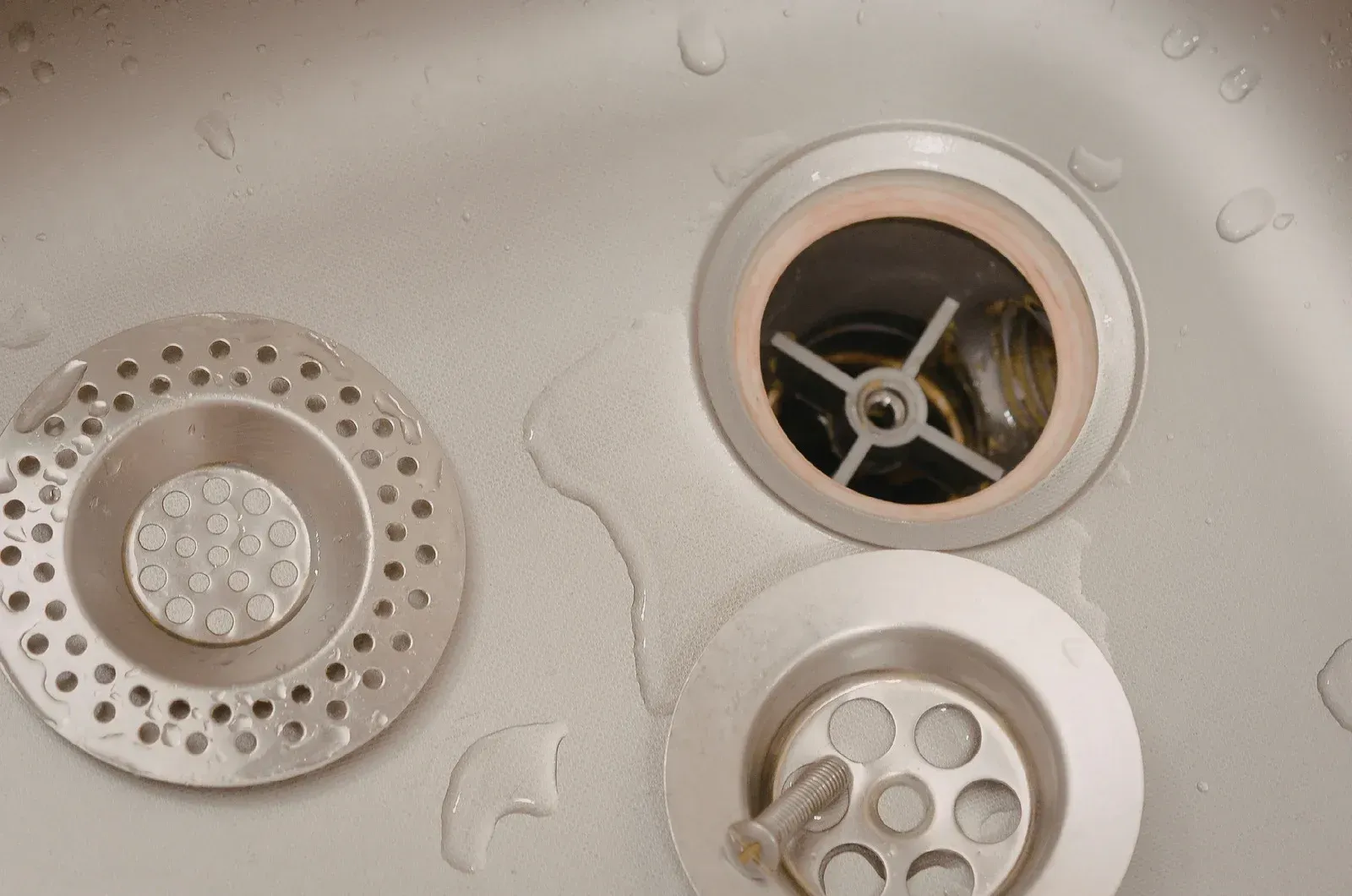 Person working on a wooden deck overlooking a lake and beach under a cloudy sky.