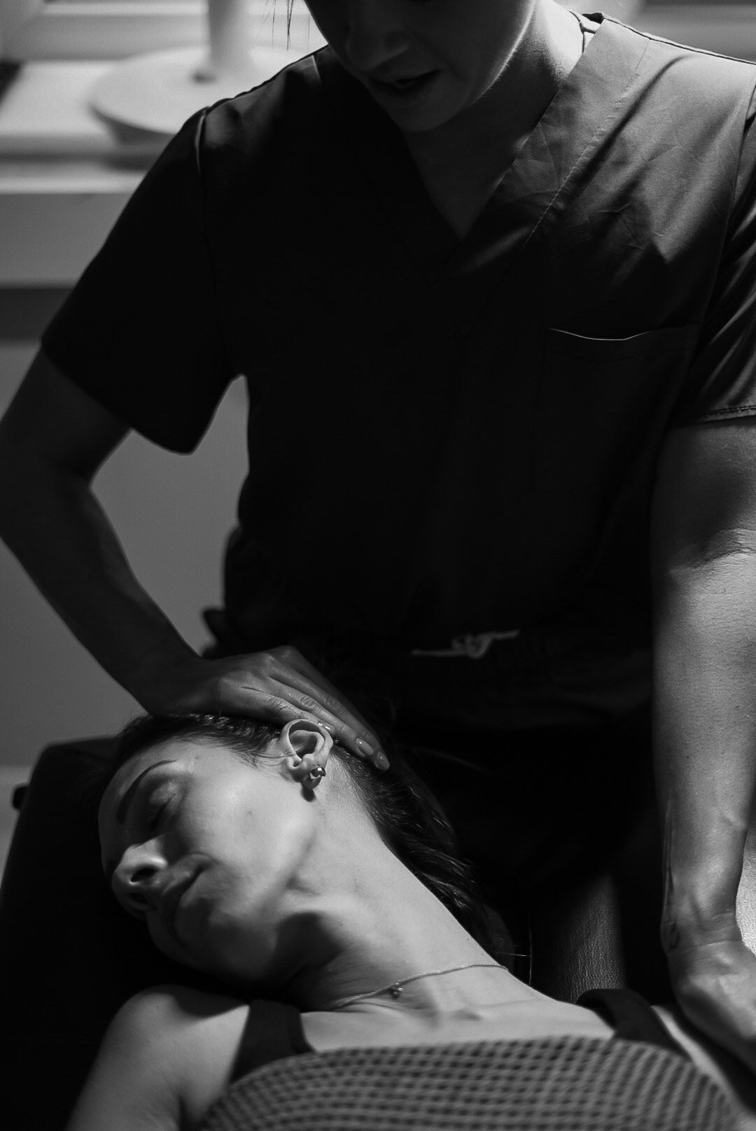 Chiropractor adjusting a woman's neck. Black and white.