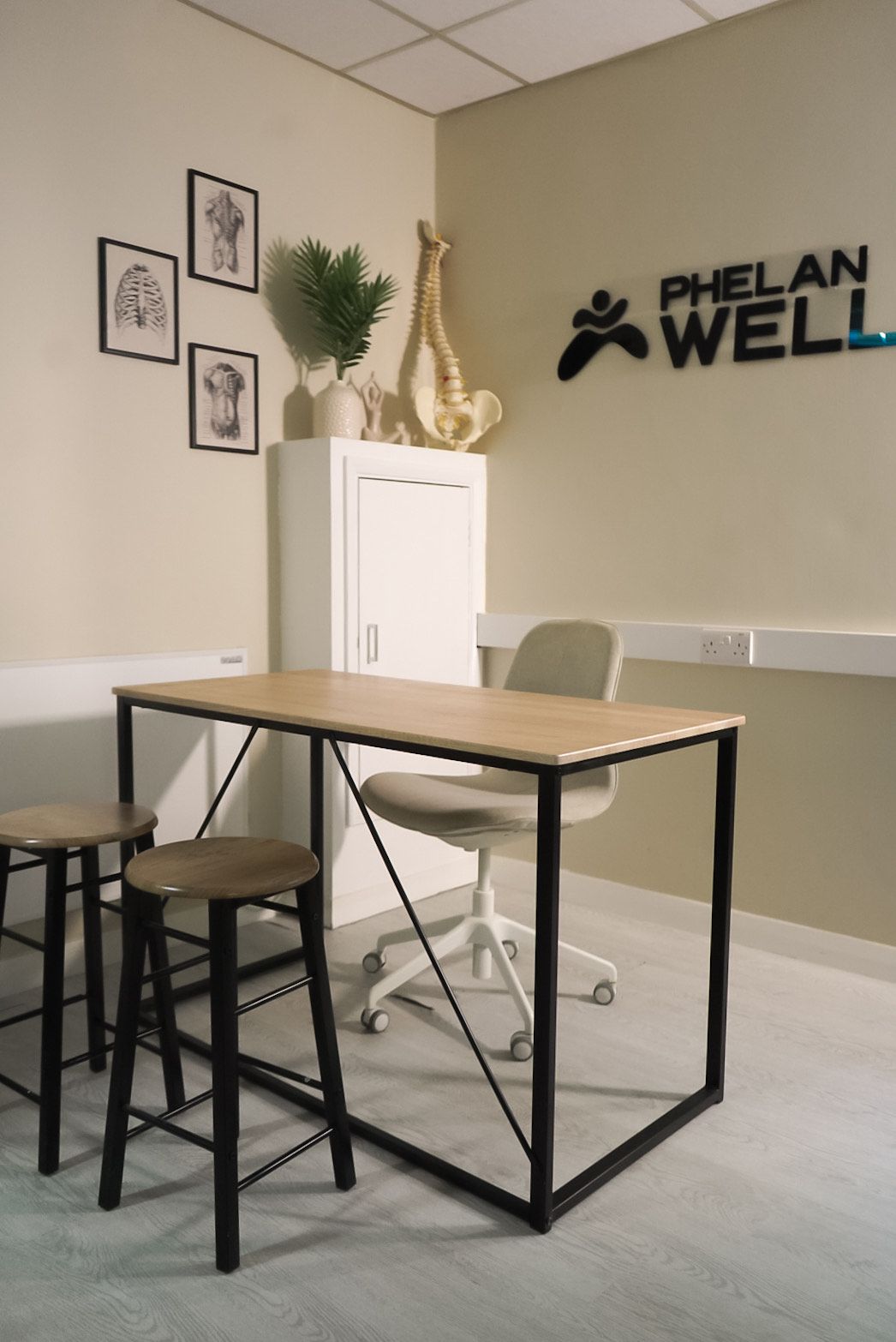 A modern office interior with a table, stools, and a chair. The 