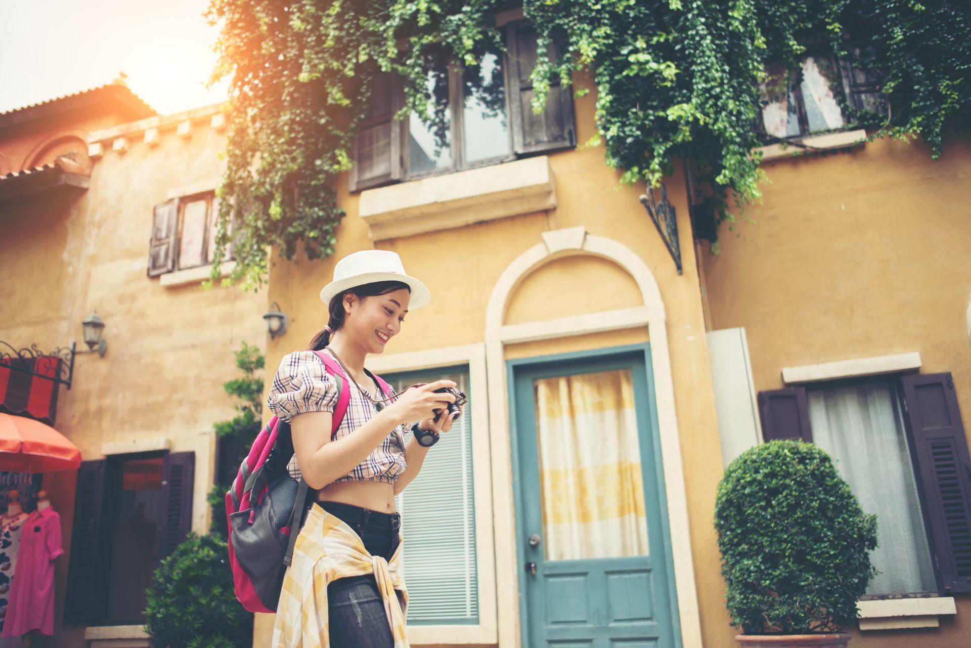 A woman is taking a picture of a building with a camera.