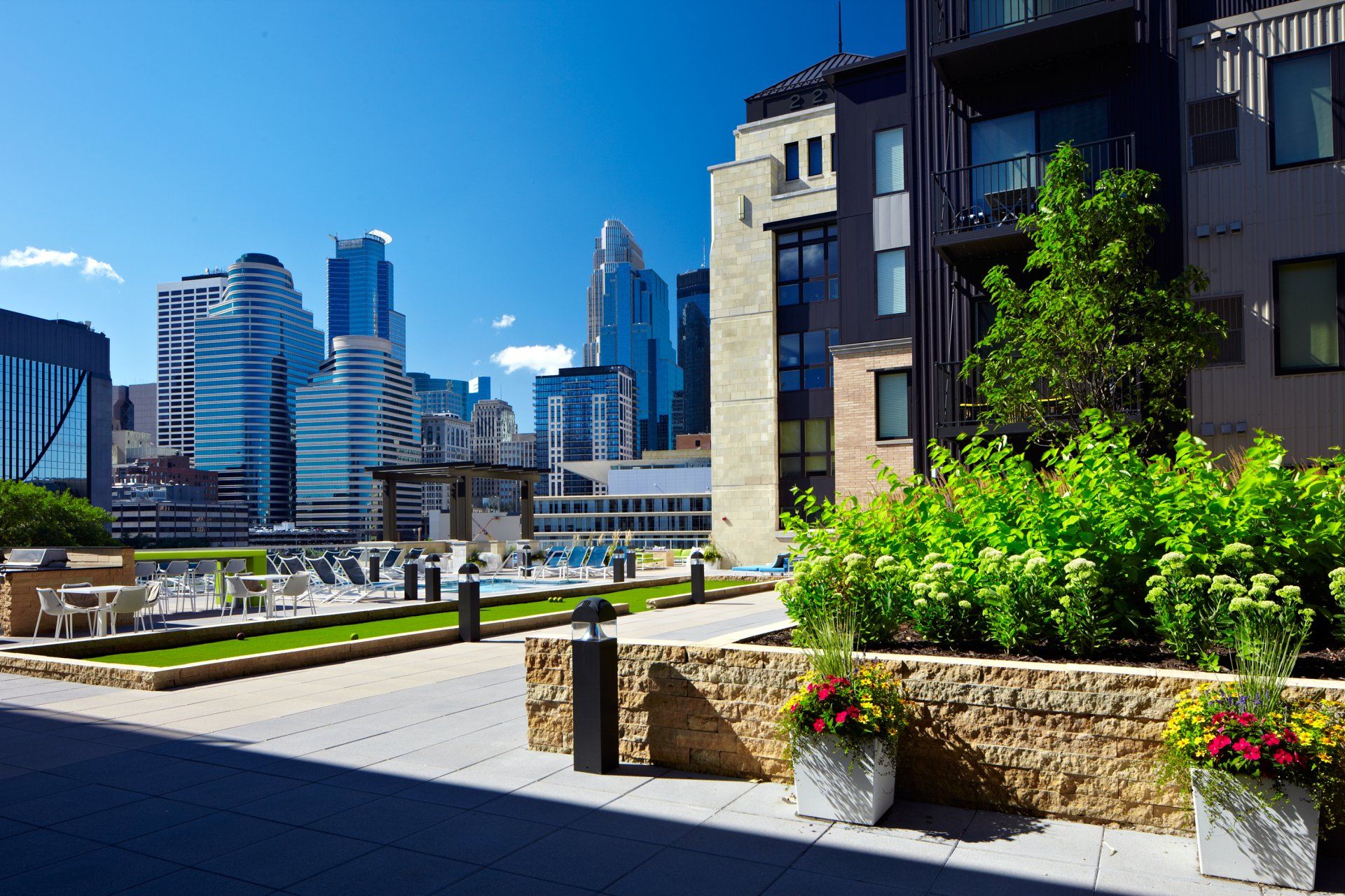 A rooftop garden with a city skyline in the background at 222 Hennepin Apartments.