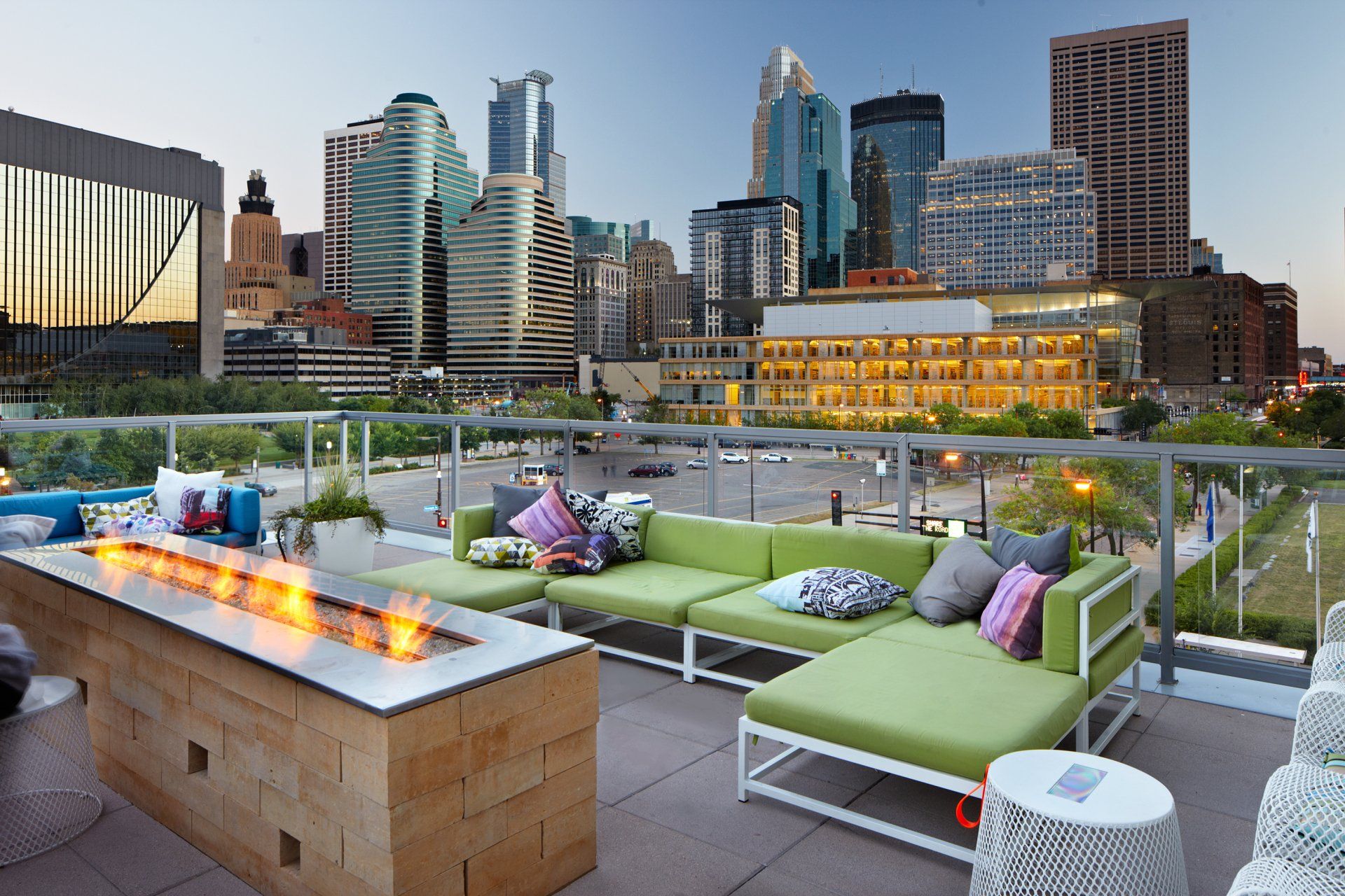 A patio with a fire pit and a view of the city skyline at 222 Hennepin Apartments.