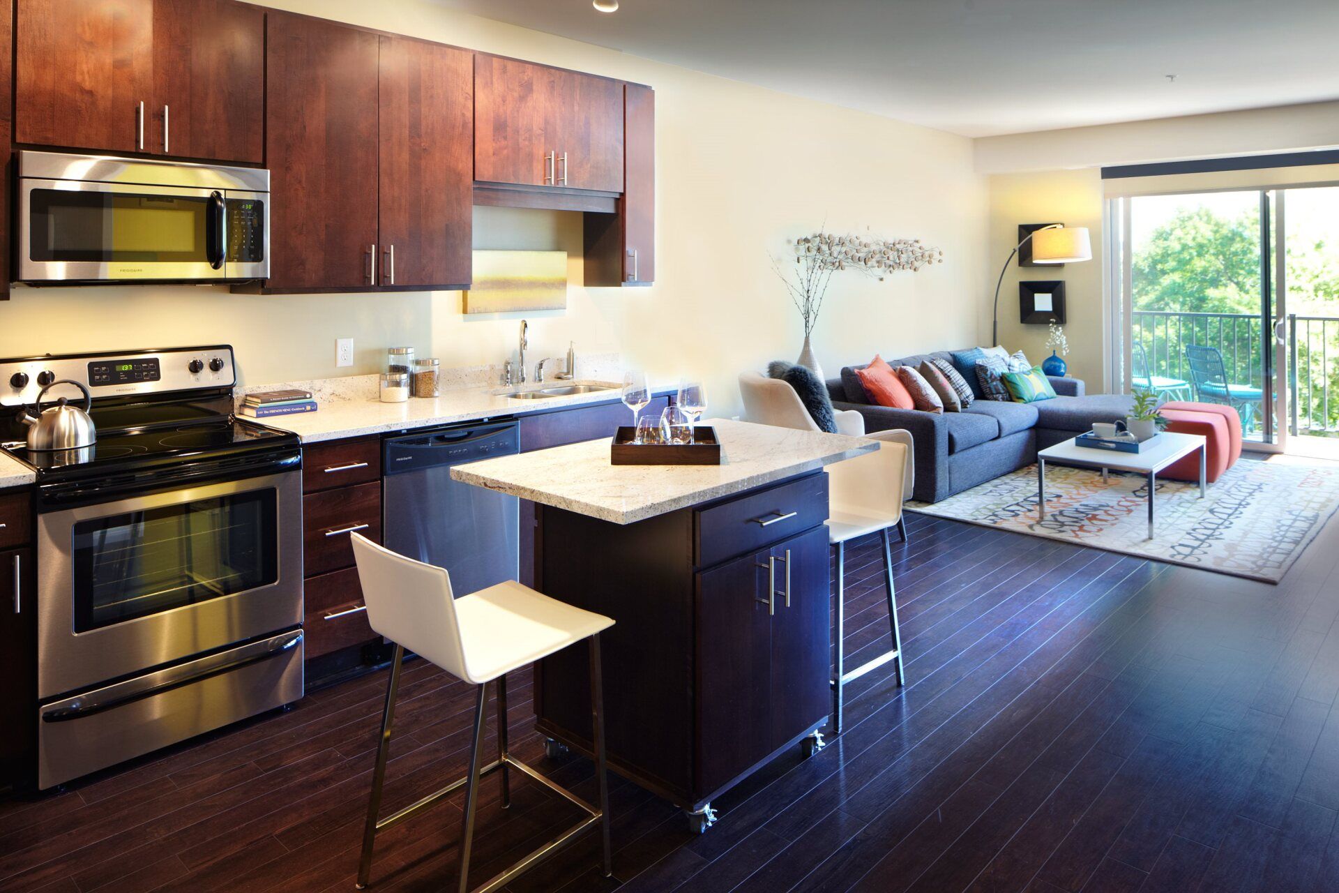 A kitchen with stainless steel appliances and wooden cabinets at 222 Hennepin Apartments.